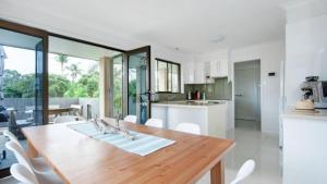 a kitchen and dining room with a wooden table and chairs at Only The Best Will Do - Pool Wifi in Hawks Nest