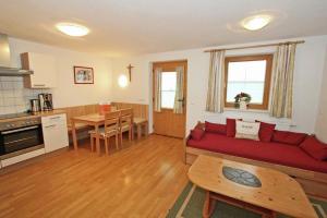 un soggiorno con divano rosso e una cucina di Apartment Kreidl a Hippach