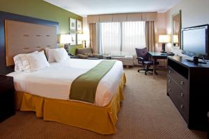 a hotel room with a large bed and a desk at Holiday Inn Express & Suites Jacksonville - Atlantic Beach by IHG in Jacksonville