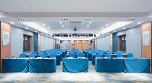 Green Tree Inn Urumqi San'gong Metro Station Exit في أورومكي: غرفة كبيرة مع طاولات وكراسي زرقاء +218 صورة