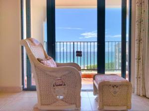 een kamer met stoelen en een balkon met uitzicht op de oceaan bij baya sea view apartment in Xinshi