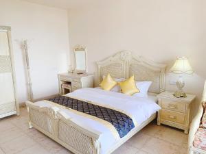 een slaapkamer met een groot bed met gele kussens bij baya sea view apartment in Xinshi