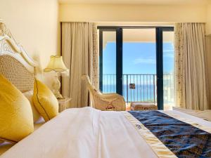 een slaapkamer met een groot bed en een balkon bij baya sea view apartment in Xinshi