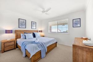 een slaapkamer met een groot bed en een raam bij Sommaroy - Pet Friendly with Fire Pit in Currarong