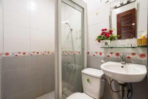 a bathroom with a shower and a toilet and a sink at Collection O Dinh Dinh Hotel - Near Tan Son Nhat Airport in Ho Chi Minh City +34 photos