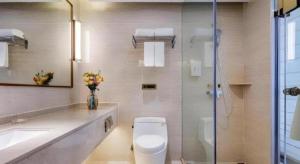 a bathroom with a toilet and a sink and a shower at Vienna Hotel Taicang Shanghai East Road Landu Branch in Zhoujiating +23 photos