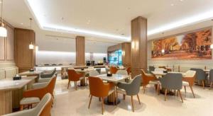 a restaurant with tables and chairs in a room at Vienna Hotel Hubei Jinzhou Changjiang University in Caoshi