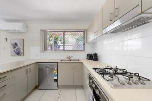 ノース・レイクスにあるMango Hill 3 Bedroom Family Accommodationのコンロとシンクのある白いキッチン