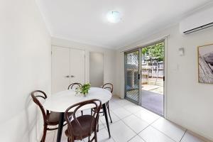 ノース・レイクスにあるMango Hill 3 Bedroom Family Accommodationのテーブルと椅子のある白いダイニングルーム +4枚の写真