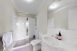 ノース・レイクスにあるMango Hill 3 Bedroom Family Accommodationのトイレと洗面台を備えた白いバスルーム