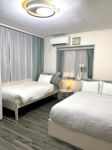 a hotel room with two beds and a couch at 那覇国際通り徒歩圏内Okinawa 住宅風ゲストルーム in Naha