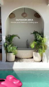 a bathroom with a bath tub with two palm trees at Semasa Jogja Villa in Adi Sutjipto +7 photos