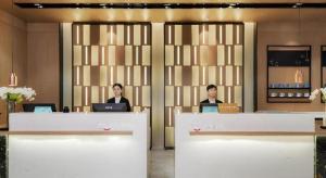 two women sitting at a counter with their laptops at Echarm Hotel Nanjing Expo Center Olympic East Metro Station in Nanjing