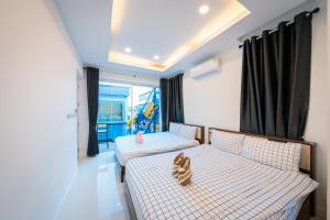 a bedroom with two beds and a balcony at Cocktail Poolvilla Pattaya in Na Jomtien +57 photos
