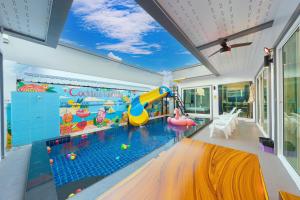 an indoor pool with a slide and a water park at Cocktail Poolvilla Pattaya in Na Jomtien