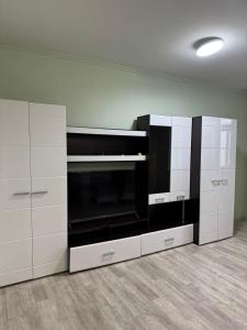 卡拉甘达Республики的厨房配有白色橱柜和大微波炉