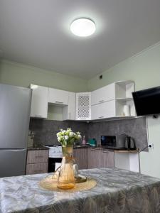 卡拉甘达Республики的厨房里有一张桌子，桌子上放着一瓶花