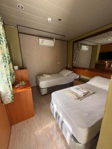 Una pequeña habitación con dos camas y una mesa. en Acs Pension House, en Koronadal