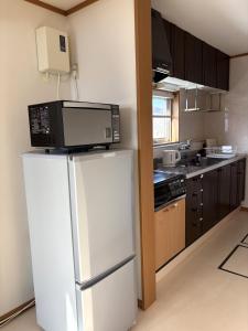 a kitchen with a white refrigerator and a microwave at Frasis in Wada