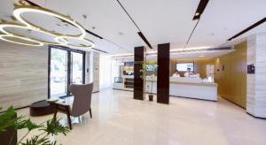 City Comfort Inn Wuhan Yangtze River Bridge Yellow Crane Tower في ووهان: لوبي مستشفى مع طاولة وكراسي