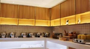 una cocina con armarios de madera, ollas y sartenes en Borrman Hotel Suzhou Wujiang Zhongshan North Road Pedestrian Street, en Suzhou 177 fotos más