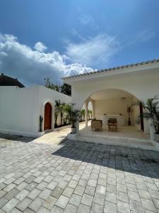 Un patio exterior de una casa blanca con un patio. en Staycationku Premium Jogja Villas, en Beran-kidul