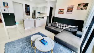 TRION KL Sky Suites KLCC View في كوالالمبور: غرفة معيشة مع أريكة وطاولة