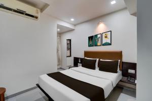 Кровать или кровати в номере Hotel O Sur Sagar Lakeview Vadodara Formerly Vintage Inn