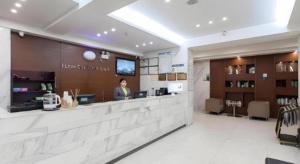 City Comfort Inn Wuhan Jiefang Avenue Xinrong Light Rail Station في ووهان: امرأة تقف في كونتر صالون