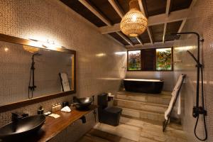 a bathroom with a black tub and a sink and a bath tub at Wild Monkey Jungle Villa - 4 Bedroom Villa in Unawatuna +16 photos