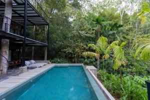 a swimming pool in front of a house with trees at Wild Monkey Jungle Villa - 4 Bedroom Villa in Unawatuna