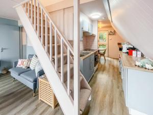 een keuken en een woonkamer met een trap in een tiny house bij Lodge 64 in Kingsdown