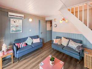 een woonkamer met twee blauwe banken en een trap bij Lodge 64 in Kingsdown