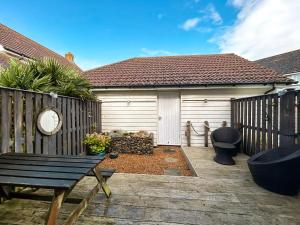 une cour arrière avec une clôture en bois et un banc dans l'établissement Dory, à Camber