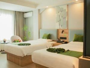 Una cama o camas en una habitación de GreenTree Inn Express Hainan Haikou Haixiu Zhong Road 185 fotos más