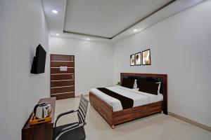 a bedroom with a bed and a desk and a television at Hotel O Sector 110 Noida Formerly Luv Kush Tower Bhangel in Noida