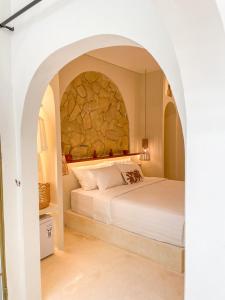 Un dormitorio con una cama grande con una pared de piedra. en Staycationku Premium Jogja Villas, en Beran-kidul 2 fotos más