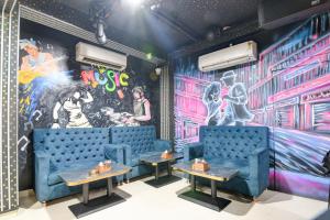 a room with two blue chairs and a mural at Collection O Dattapukur Railway Terminal Kolkata in Bārāsat