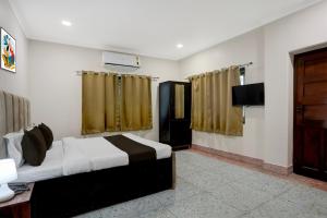 a bedroom with a bed and a flat screen tv at Collection O Civil Lines Prayagraj in Prayagraj +22 photos