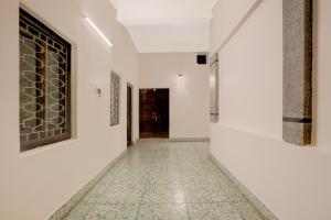 a hallway with white walls and a tile floor at Collection O Civil Lines Prayagraj in Prayagraj