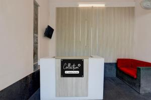 a waiting room with a red chair and a sign at Collection O Civil Lines Prayagraj in Prayagraj