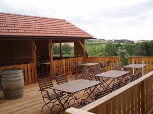 eine Terrasse mit Tischen, Stühlen und einem Fass in der Unterkunft Gasthof Christine Enne in Albrechtsberg an der Grossen Krems