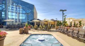 Atlantis Casino Resort Spa في رينو: فناء مع حوض استحمام ساخن وكراسي ومبنى