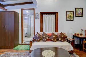 Midhill Cottage by Palette | Garden | Indoor Games | Shillong في شيلونغ: غرفة معيشة بها سرير وطاولة