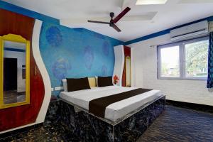 a bedroom with a large bed with a ceiling fan at Collection O Sirkazhi Formerly Navagiraga Resort in Vaithīsvarankoil