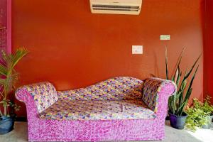 a pink couch sitting in a room with plants at Collection O Sirkazhi Formerly Navagiraga Resort in Vaithīsvarankoil