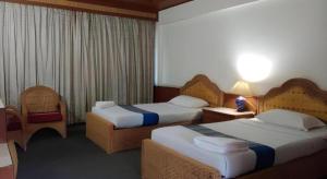 a hotel room with two beds and a table at Pailyn Hotel in Sukhothai +54 photos