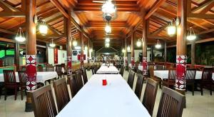 Un comedor con mesas y sillas en un edificio. en Hotel Batik Yogyakarta, en Yogyakarta