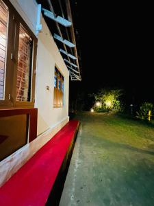 ein roter Teppich an der Seite eines Gebäudes bei Nacht in der Unterkunft Idam Homestay - Entire 3 Bedroom Holiday Home in Idukki