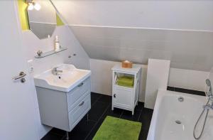 a white bathroom with a sink and a tub at Unter den Kiefern 62 in Röbel +12 photos